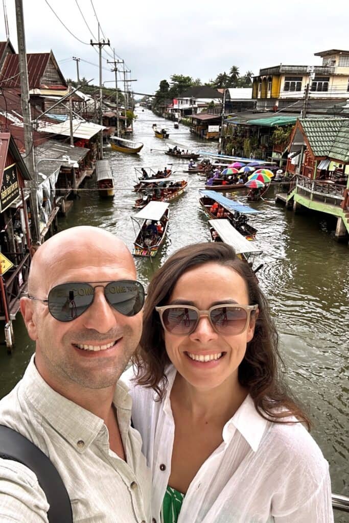 Damnoen Saduak Floating Market’te kanal ve tekneler önünde çift selfie fotoğrafı, Tayland yüzen pazar.
