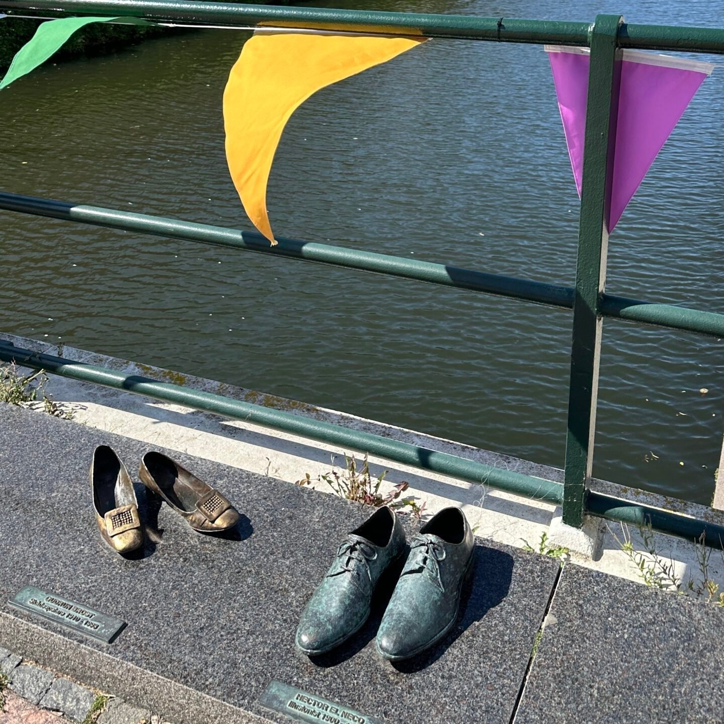 Malmö kanalında köprü üzerinde bronz ayakkabı heykelleri ve renkli süslemeler, İsveç