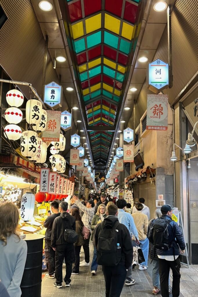 Kyoto Nishiki Market içinde Japon atıştırmalıkları ve kalabalık alışveriş sokağı