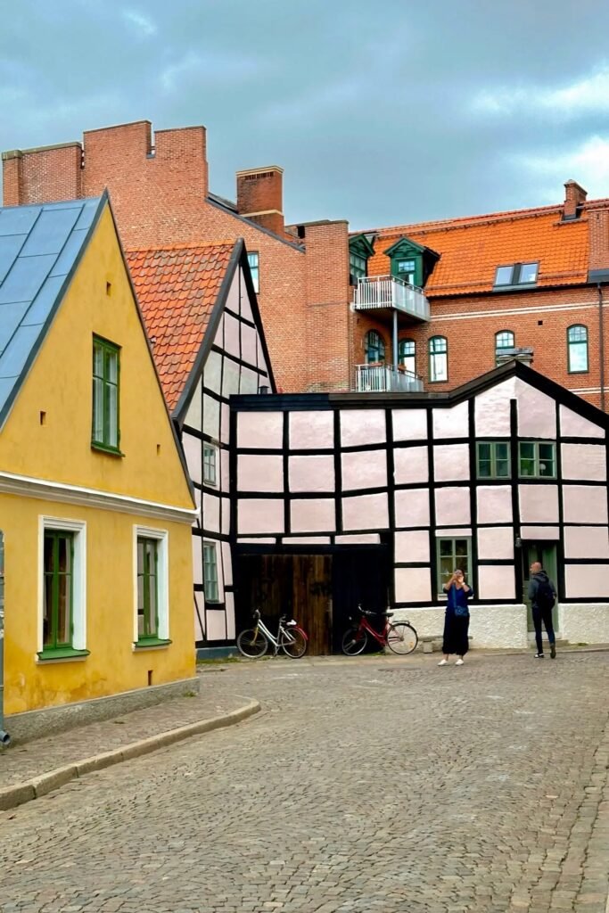 Lund’da turuncu ve sarı renkli küçük evler, kiremit çatı ve sakin sokak manzarası