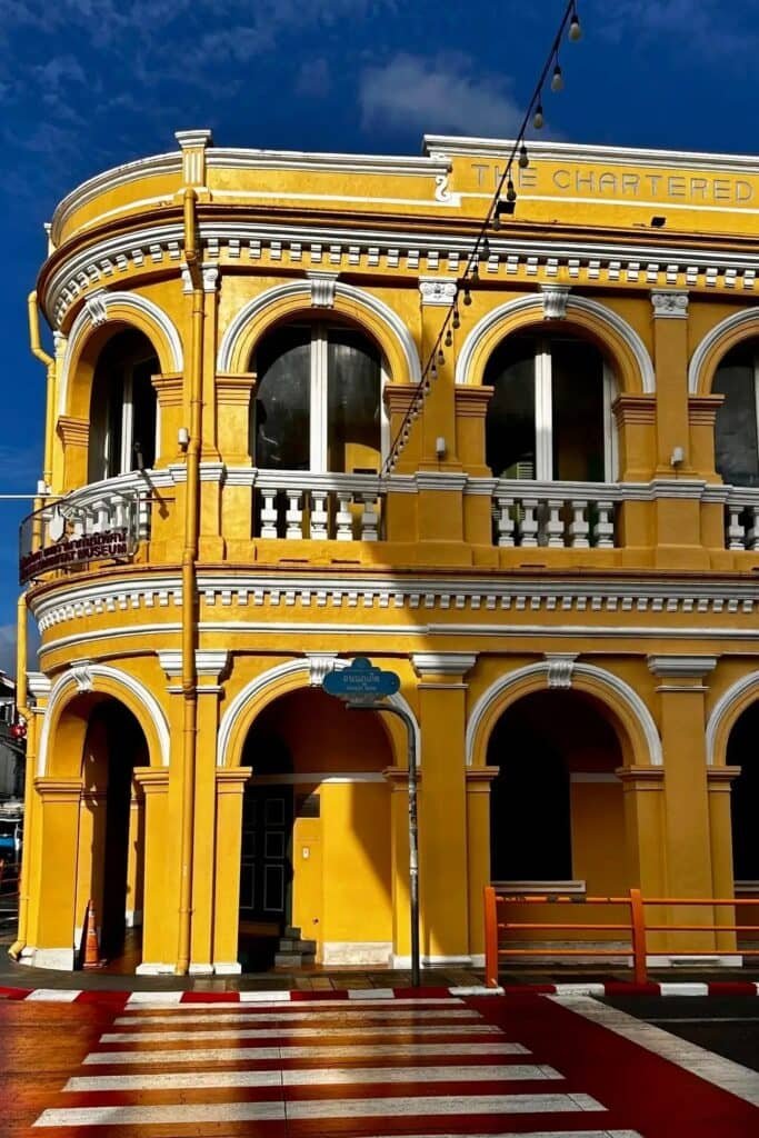 Phuket Old Town’da sarı renkli Sino-Portekiz tarzı tarihi bina ve kemerli cephe.