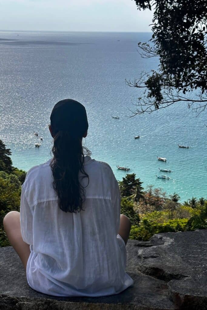 Phuket’te kayalıklardan görünen turkuaz koy ve demirli longtail tekneler.