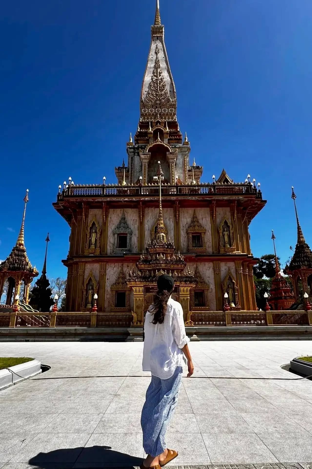 Phuket Wat Chalong Tapınağı dış cephesi: mavi gökyüzü altında Tayland tapınak mimarisi ve avlu