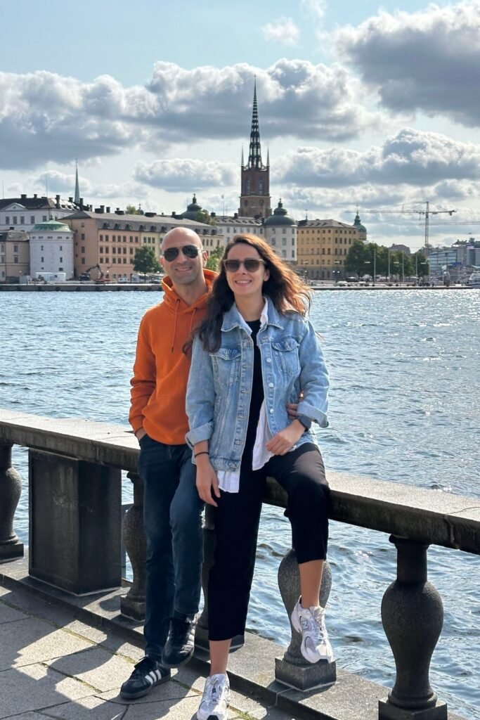 Stockholm’de çift fotoğrafı, arka planda şehir silüeti ve kuleli tarihi yapı manzarası