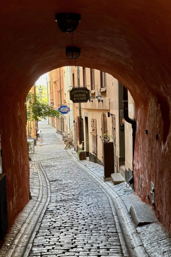 Stockholm Gamla Stan’da kemer altından görünen dar taş sokak ve tarihi geçit