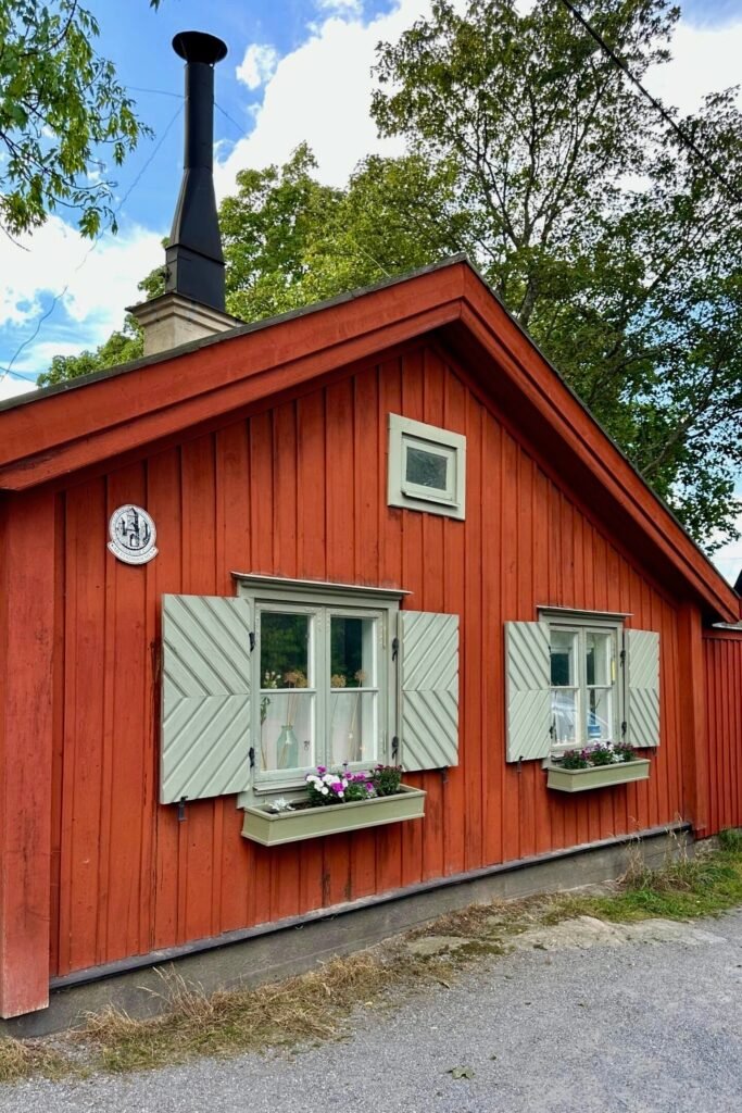 Stockholm Södermalm’de kepenkli pencereleri ve çiçek kutuları olan kırmızı ahşap İsveç evi