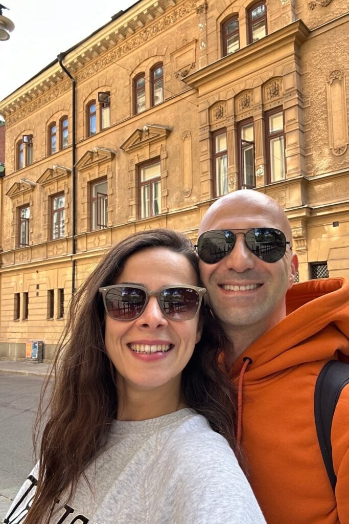 Stockholm’de tarihi sokakta çekilmiş çift selfie fotoğrafı, arka planda klasik İsveç mimarisi, gezi rehberi