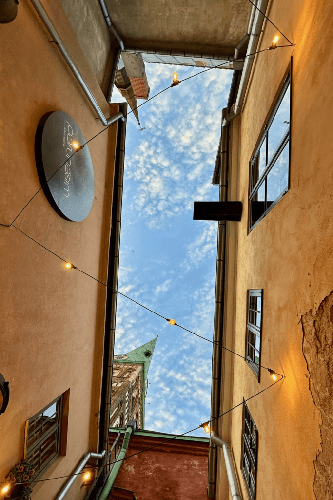 Riga gezisinde Old Town sokakları arasından görülen tarihi kilise kulesi, Riga gezi rehberi gizli kalmış duraklar