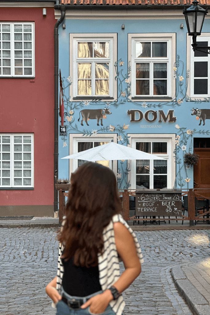 Riga Old Town’da pastel cepheli DOM Restorans binası ve taş sokak görünümü