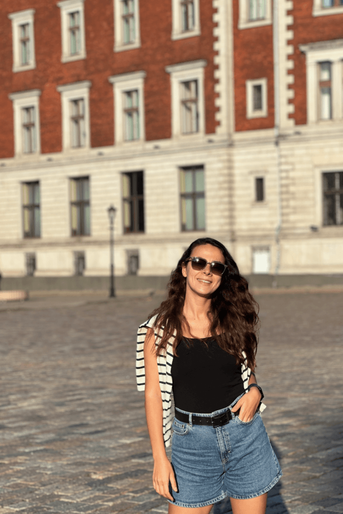 Riga Old Town’da taş meydanda kırmızı tarihi bina önünde fotograf noktası