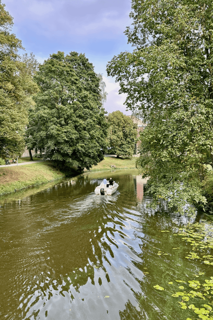 Riga Esplanade Park ağaçlar arasında ilerleyen gezi teknesi